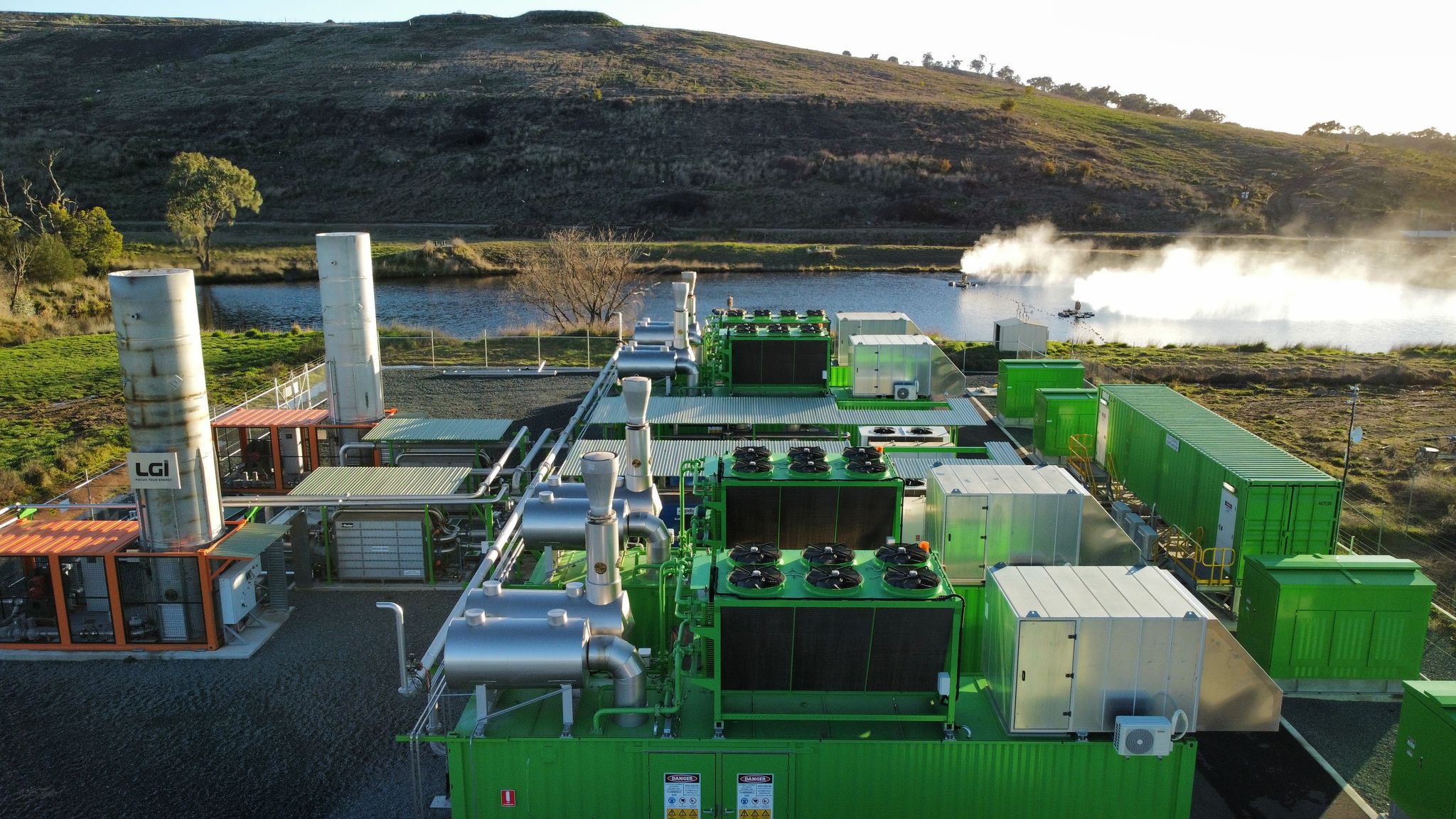 A green coloured processing plant with pipes. 