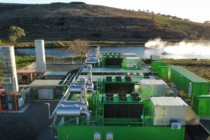 A green coloured processing plant with pipes. 