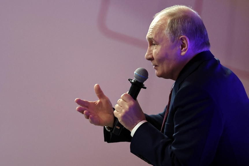 Vladimir Putin gestures with his hand