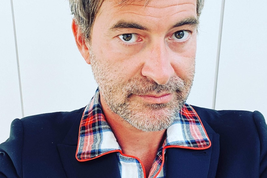 Actor Mark Duplass is wearing a flannel and a suit jacket.