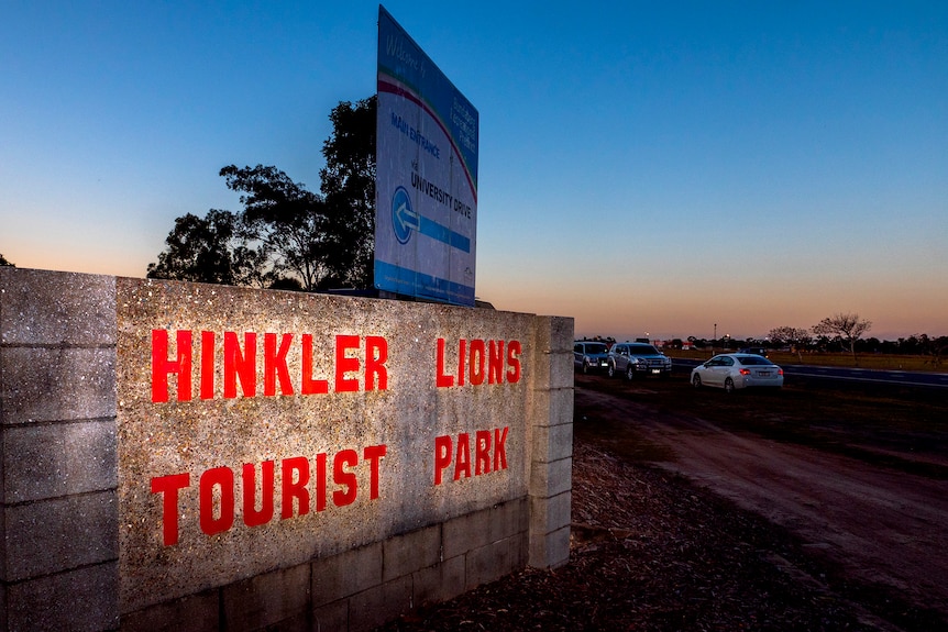 A sign at sunset with the words Hinkler Lions Tourist Park.