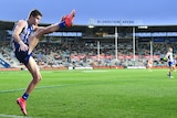 North Melbourne's Bailey Scott completes a shot for goal at Bellerive Oval against the GWS Giants.