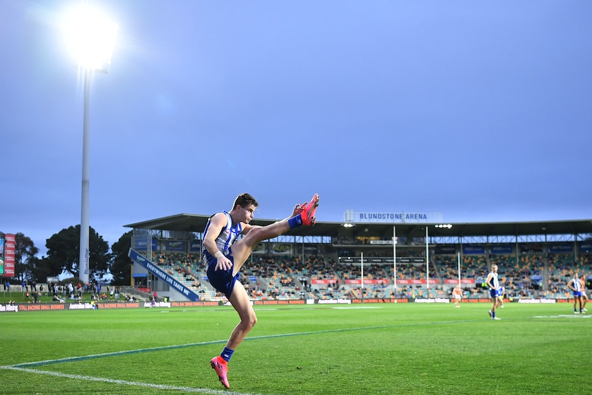 North Melbourne's Bailey Scott completes a shot for goal at Bellerive Oval against the GWS Giants.