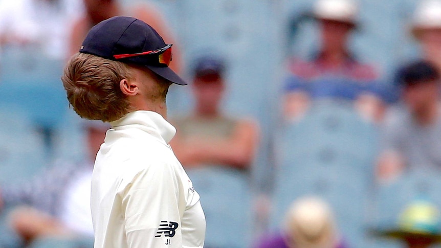 Joe Root with a hat over his face.