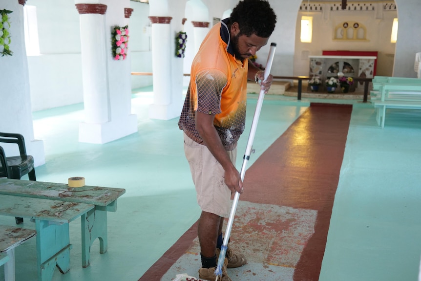 Man pains the floor inside a church