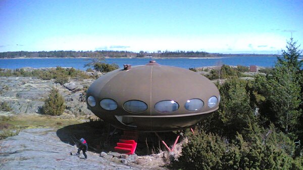 A UFO shaped house on a hill.