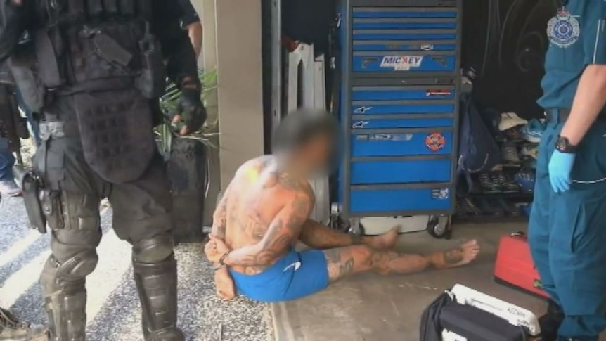 A bikie is arrested as part of the raids.