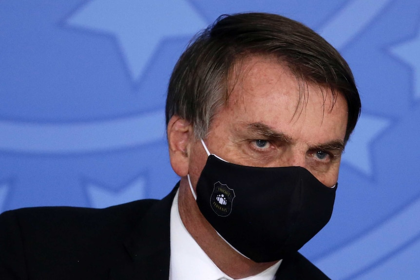 Jair Bolsonaro wears a black mask