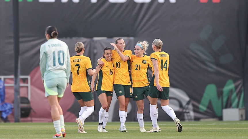 Matildas players congratulate Hayley Raso after a goal in a friendly against Mexico.