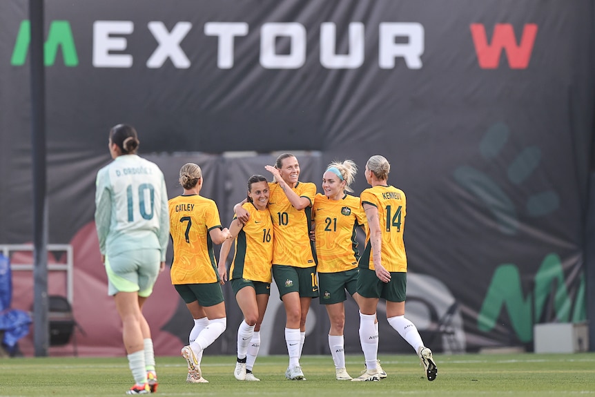 Matildas players congratulate Hayley Raso after a goal in a friendly against Mexico.