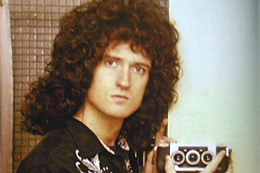 Queen guitarist Brian May holds up a 3D camera.