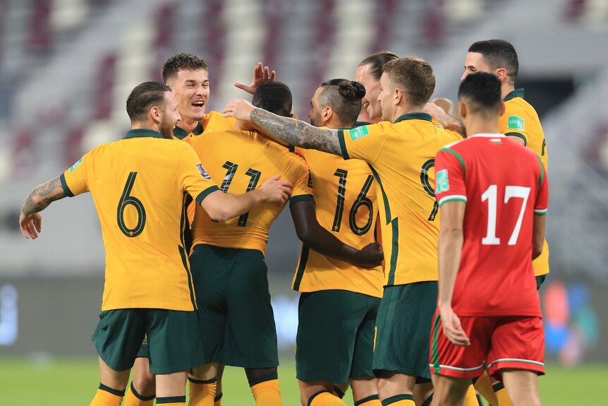 Socceroos players hug and celebrate