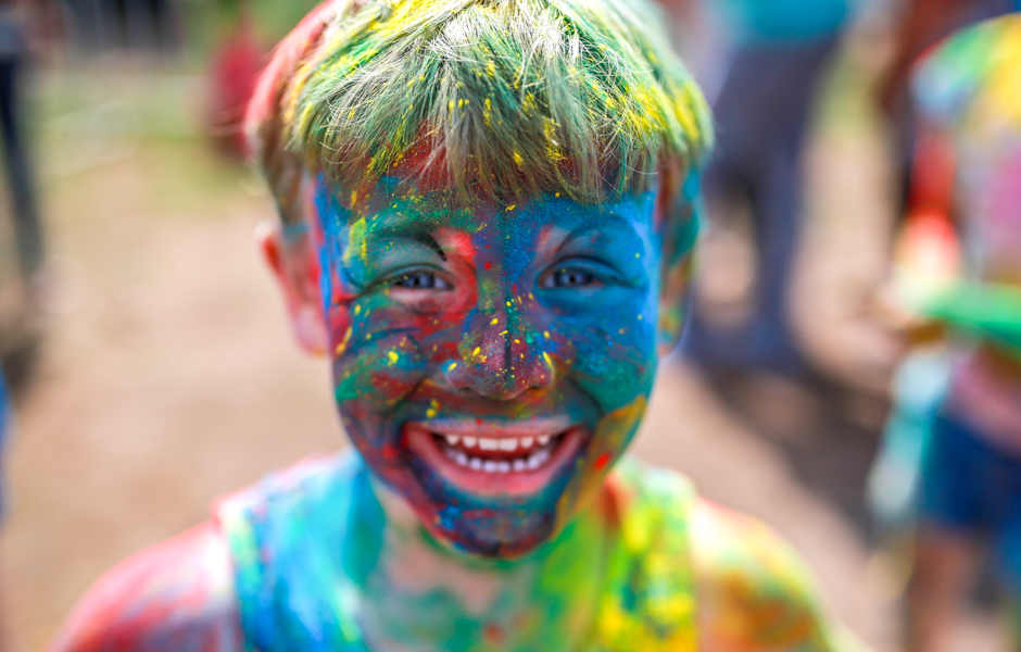 A little boy covered in coloured powder