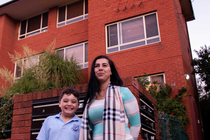 Rima Israel and her son stand outside an apartment block