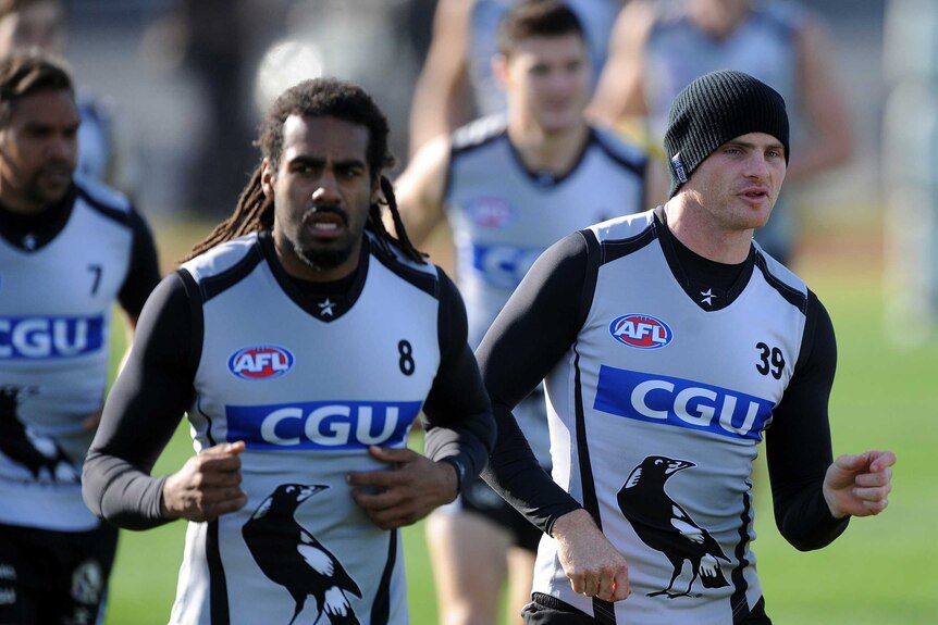 Two AFL players run during training.