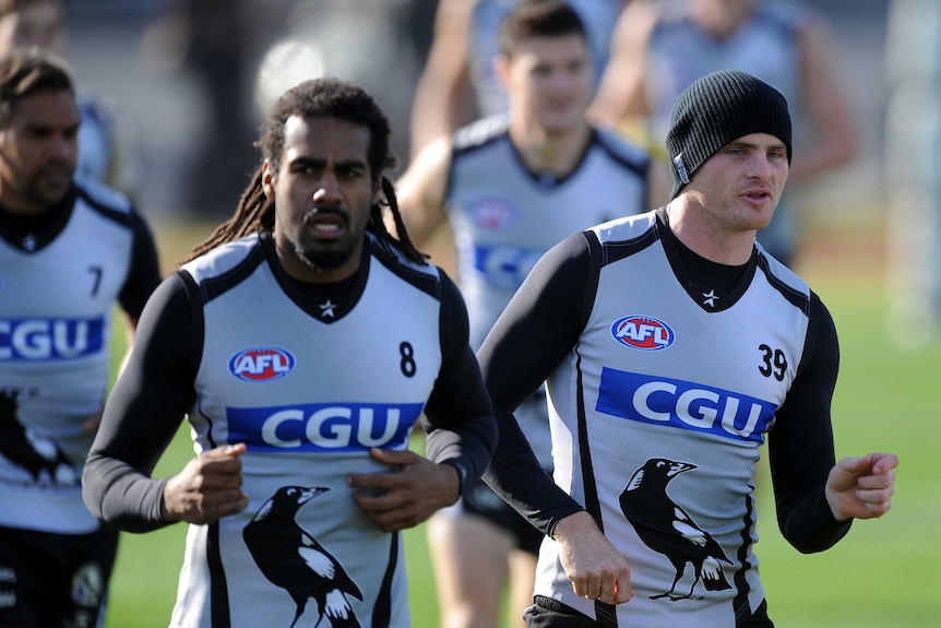 Two AFL players run during training.