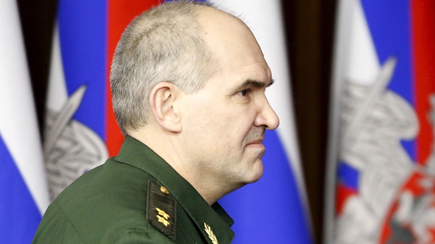 profile of a man in military uniform with Russian blue, red, white flag behind