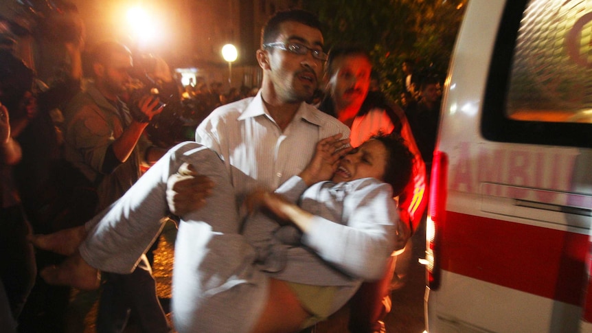 Man carries woman wounded in Israeli airstrike in Gaza