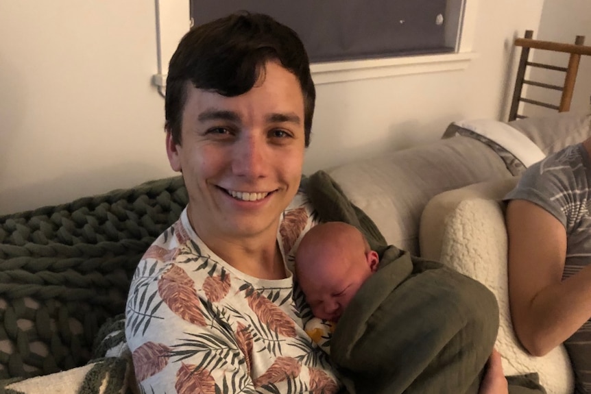 Andrew Parchimowicz holds a baby.