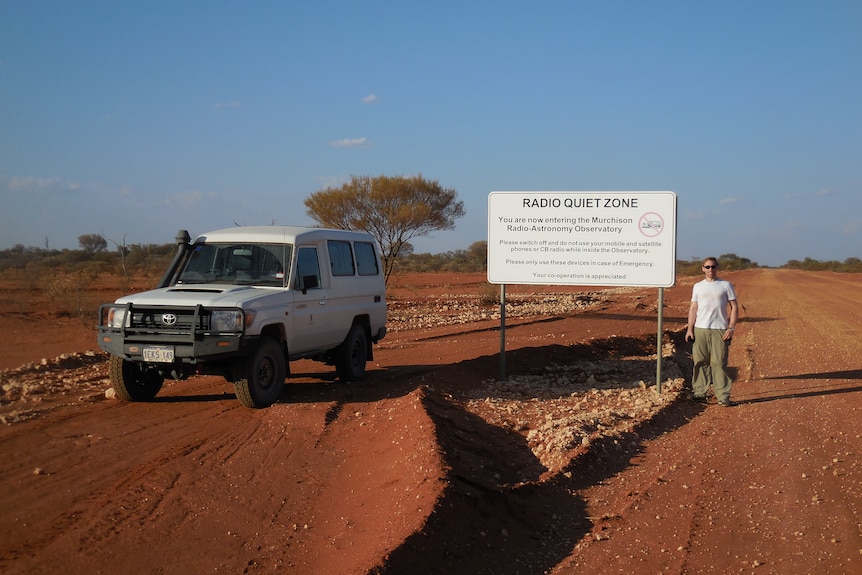 David standing next to the radio quiet zone sign in outback WA