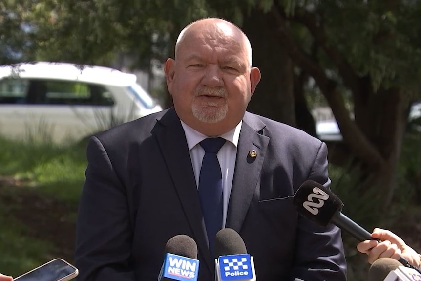 A head shot of a man with microphones around him