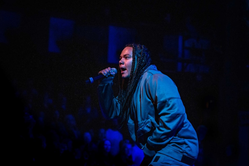 Colour photo of Jesswar perfomring on stage at Sydney Opera House.