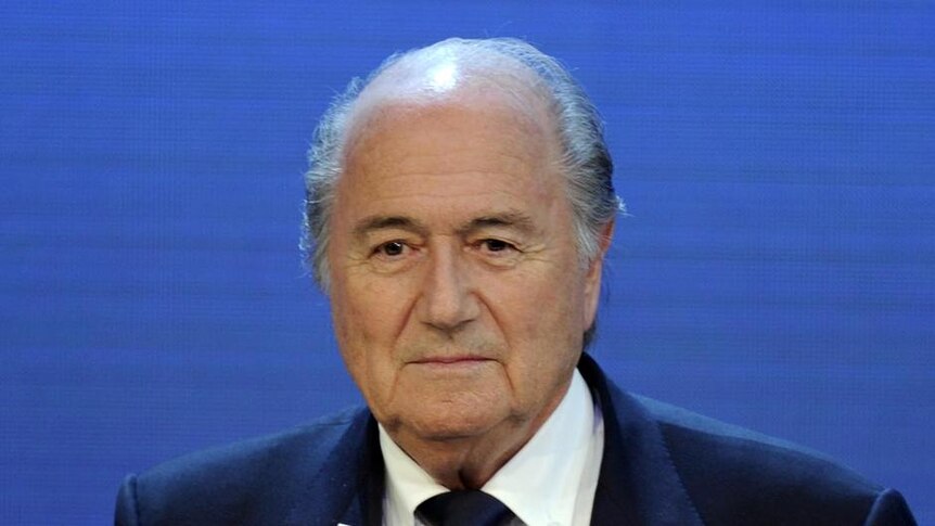 FIFA president Sepp Blatter holds up the name of Qatar as successful bidder for 2022 World Cup.