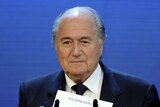 FIFA president Sepp Blatter holds up name of Qatar during announcement of hosts for 2022 World Cup.