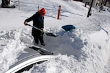 Woman digs car out of snow after US blizzard