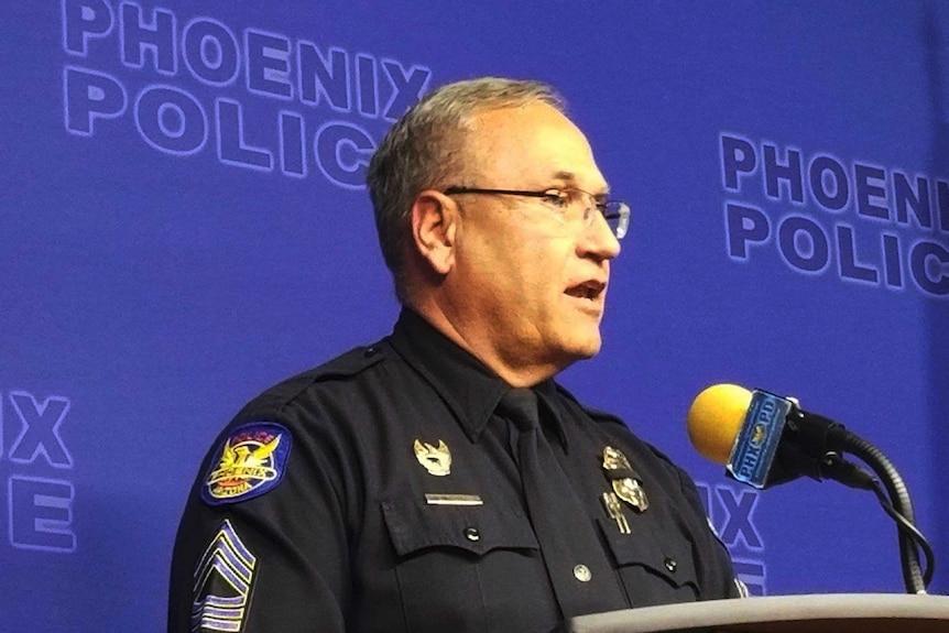Phoenix Police spokesman Tommy Thompson at a podium speaking at a news conference.