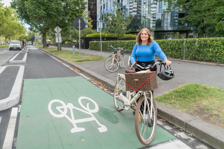 woman standing with a bike on a bike path 