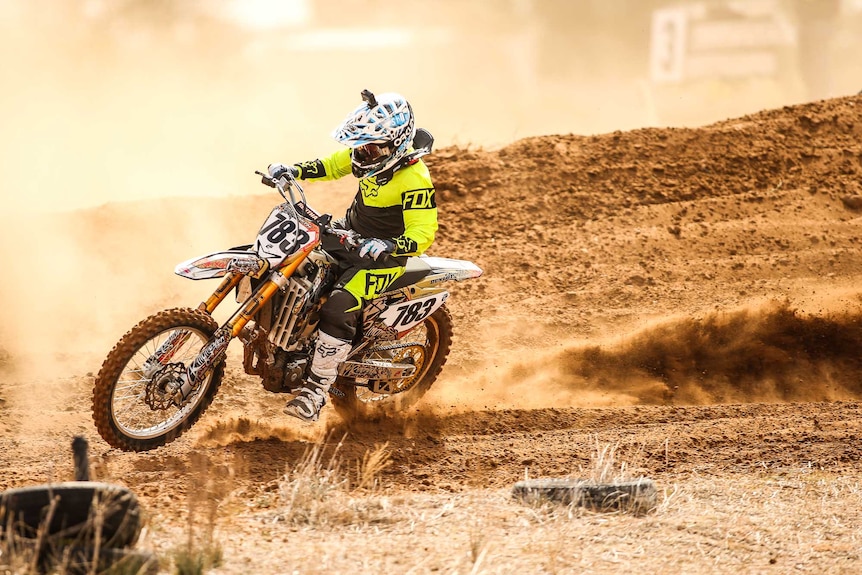 beautiful motorcross photo with rider ripping up some soft yellow dust