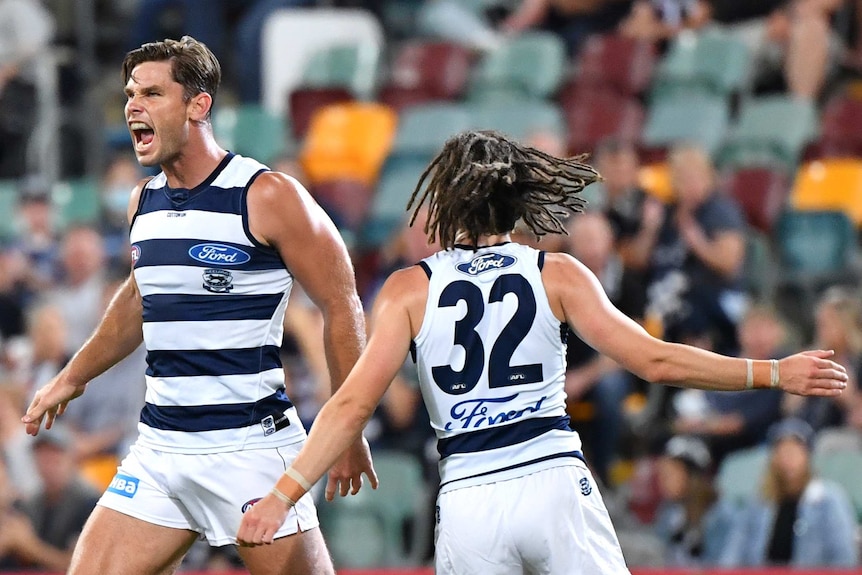 Two Geelong AFL players celebrate a goal against Collingwood.