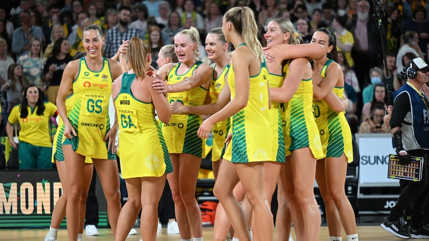 Team Australia members hug each other on the court. 