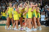 Team Australia members hug each other on the court. 