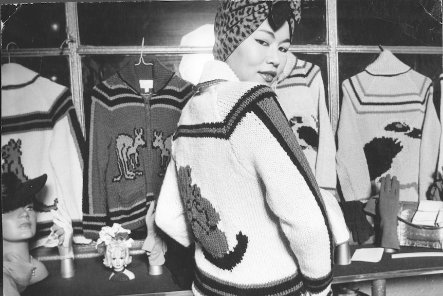 Black and white photo of woman wearing a jumper with animal motif on the back.