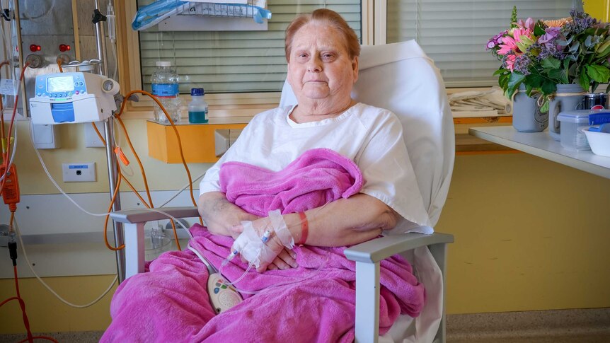 Carol Clark sitting in a hospital chair at Westmead, hooked up to antibiotics.