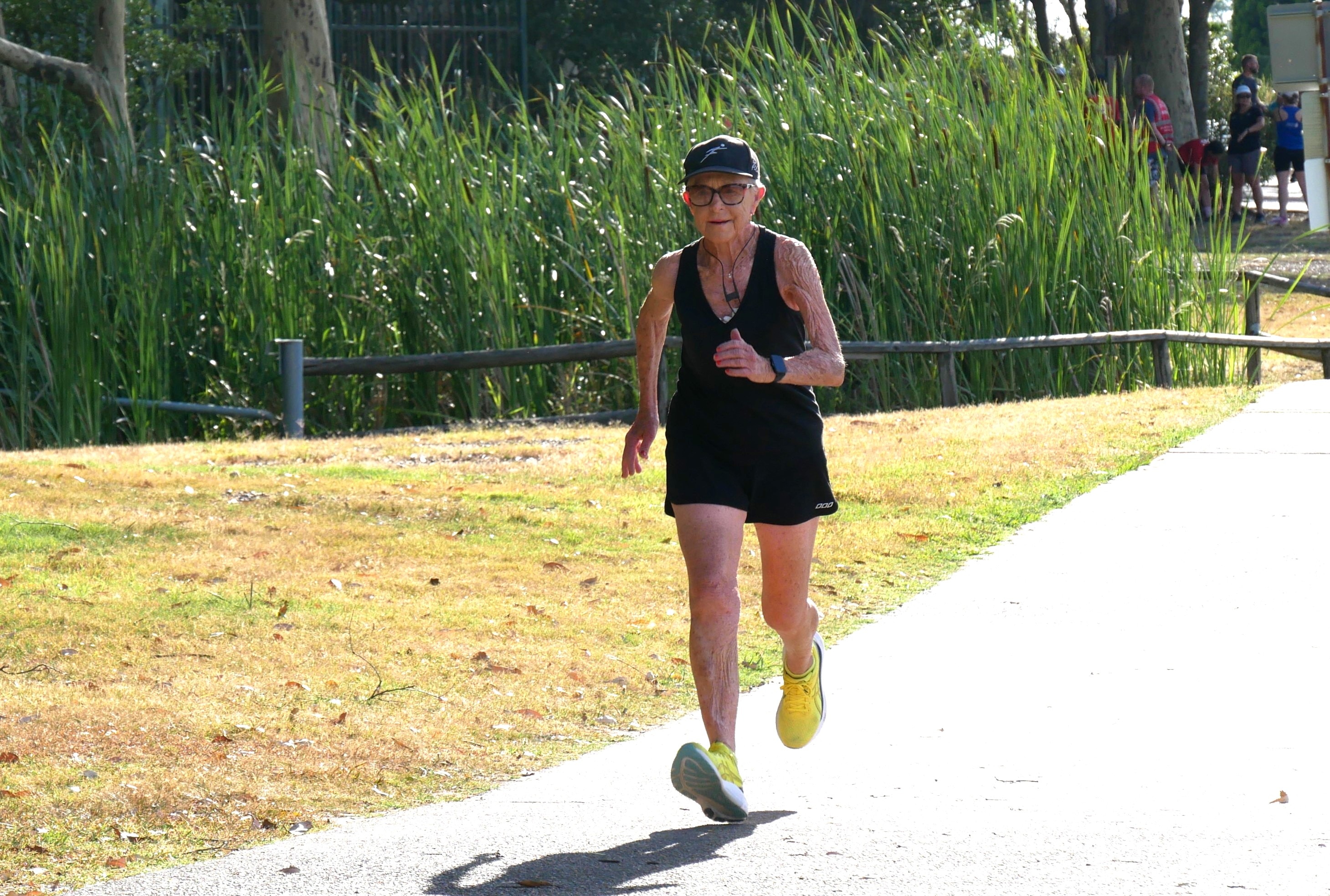 Nancy correndo com uma camiseta preta e shorts com sapatos amarelos brilhantes. 
