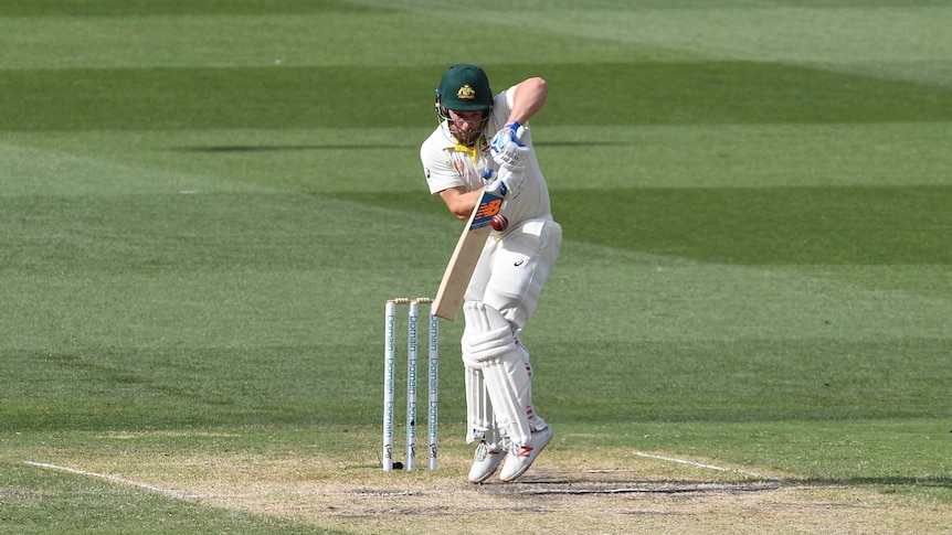 Australia batsman Aaron Finch jumps while playing a defensive stroke during a Test at the MCG.