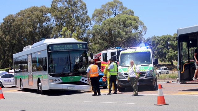 The bus has its bumper hanging off, an ambulance and firetruck nearby.