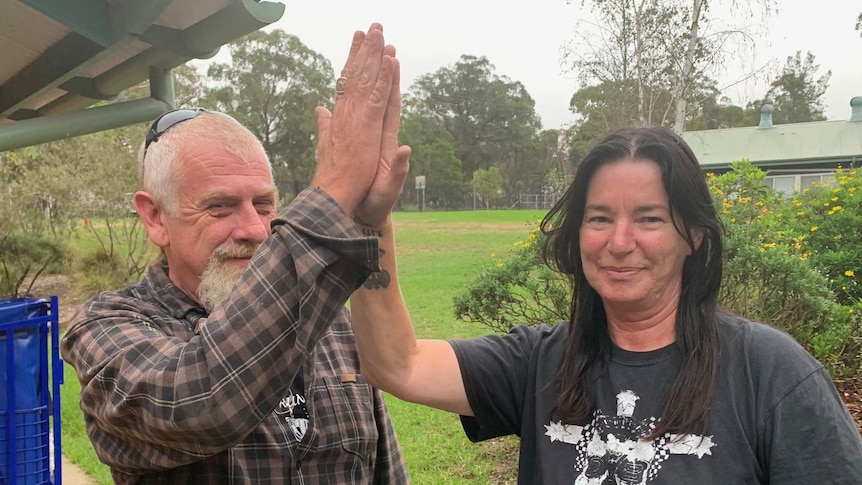 a man and woman touch hands in a high five