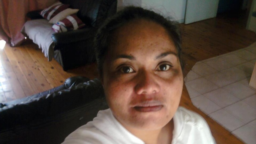 woman with dark hair in living room looking into camera