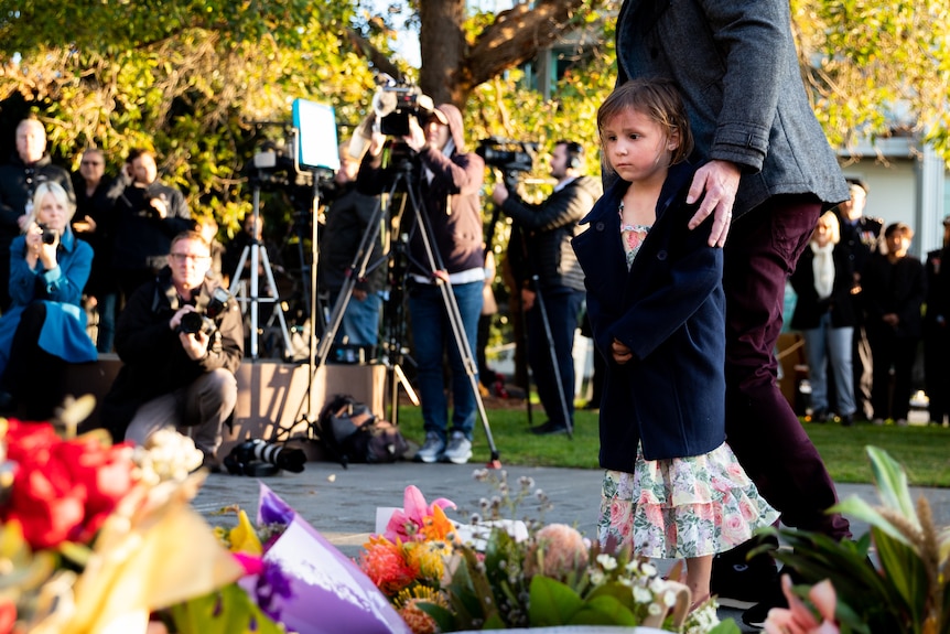 A girl lays flowers during a memorial service for the Bali bombings.