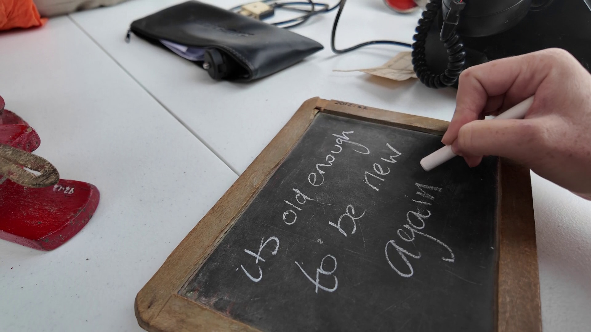 Una mano escribe en una pizarra