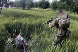 SAS soldier points gun at Afghan man