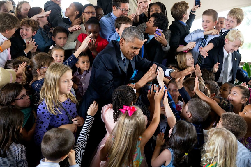 US President Barack Obama high-fives children at the US Embassy in Nairobi.