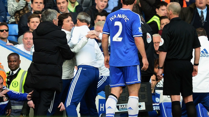 Chelsea coach Rui Faria is restrained by Jose Mourinho as he confronts referee Mike Dean.