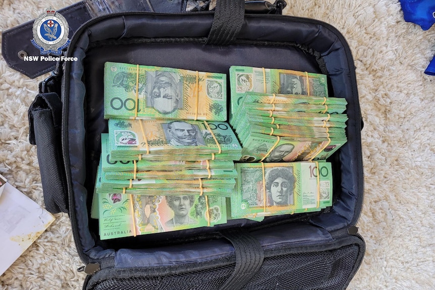 Stacks of $100 notes in a suitcase.