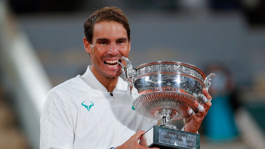 Spain's Rafael Nadal bites the trophy as he celebrates winning the final match of the French Open tennis tournament.