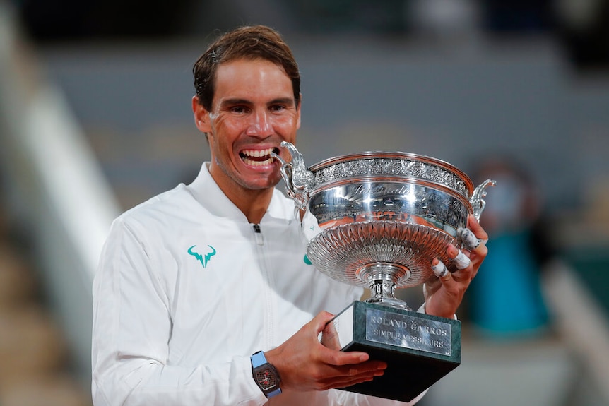 Spain's Rafael Nadal bites the trophy as he celebrates winning the final match of the French Open tennis tournament.